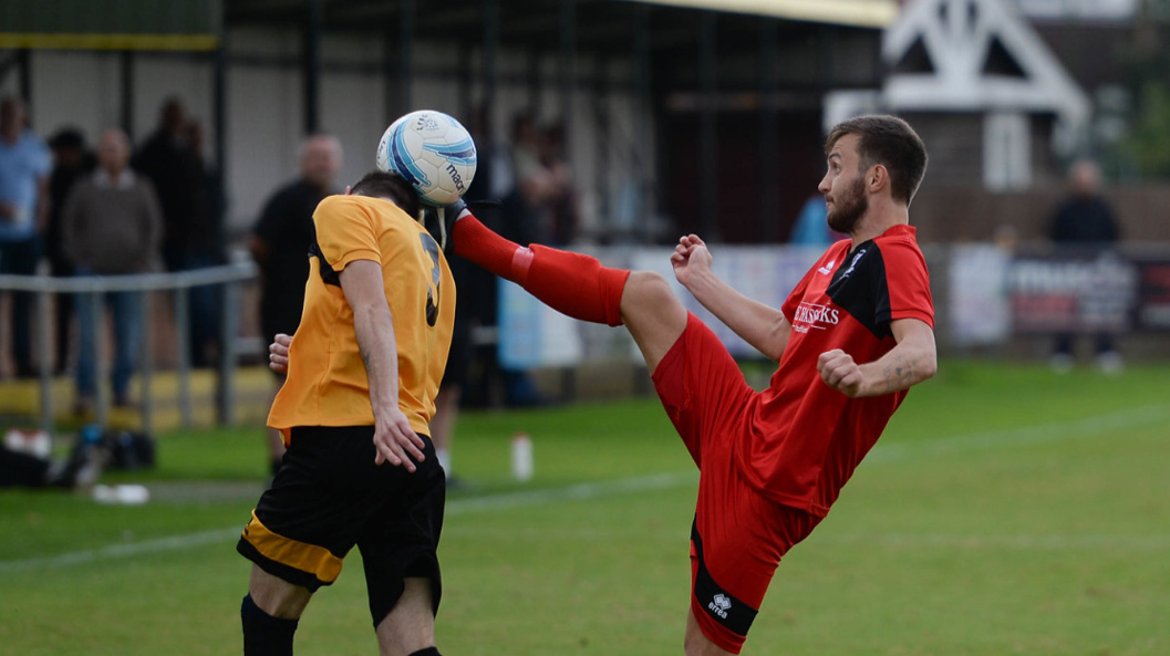 Hassocks' Harry Mills challenges a Littlehampton Town player for the ball