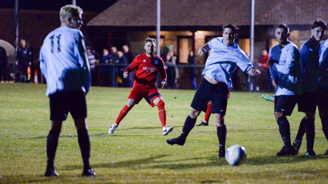 Hassocks' Michael Death hits a free kick through a crowd of players against Billingshurst