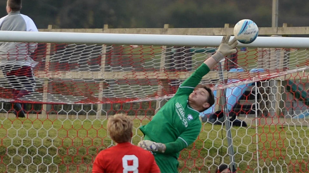Hassocks goalkeeper James Broadbent makes an excellent save against Pagham