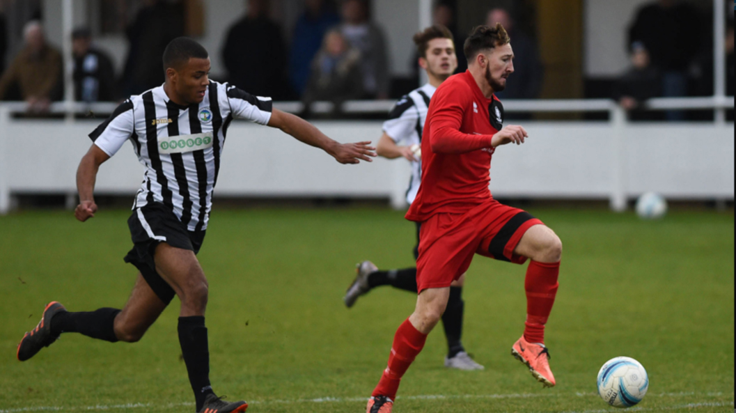 Hassocks striker Ben Bacon runs at the Peacehaven & Telscombe defence