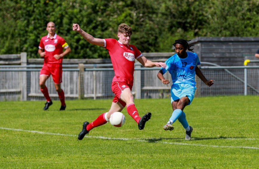Hassocks defender Luke Marshall makes a tackle on a Sutton Common Rovers player