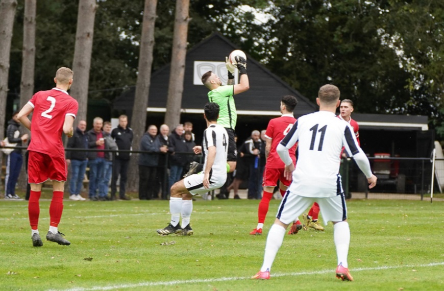 Hassocks goalkeeper Alex Harris claims a high cross in the Southern Combination Premier Division game at Loxwood