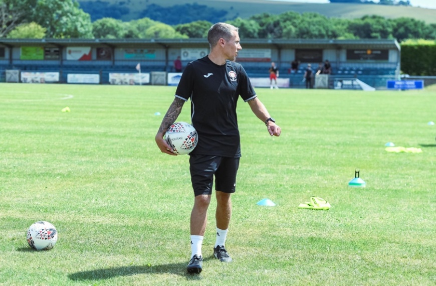 Hassocks head coach James Westlake leads the warm up ahead of the pre-season game against Epsom & Ewell