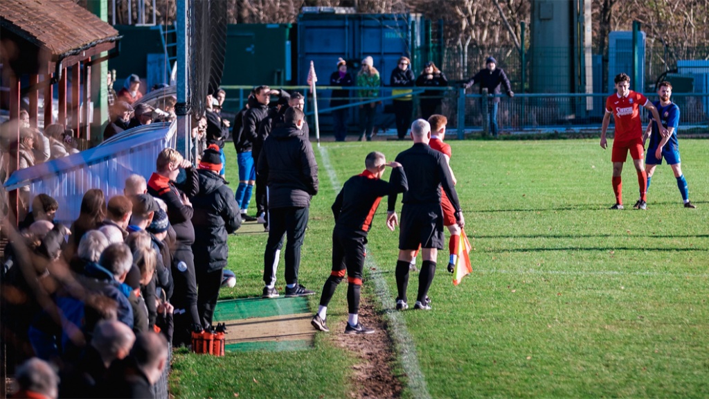 The dugouts at the Beacon with a busy crowd watching Hassocks take on Steyning Town on Boxing Day 2022