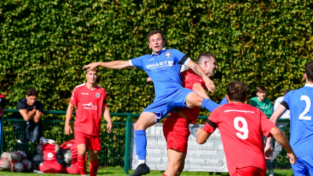 Hassocks midfielder Mike Williamson challenges for a header against Crawley Down Gatwick