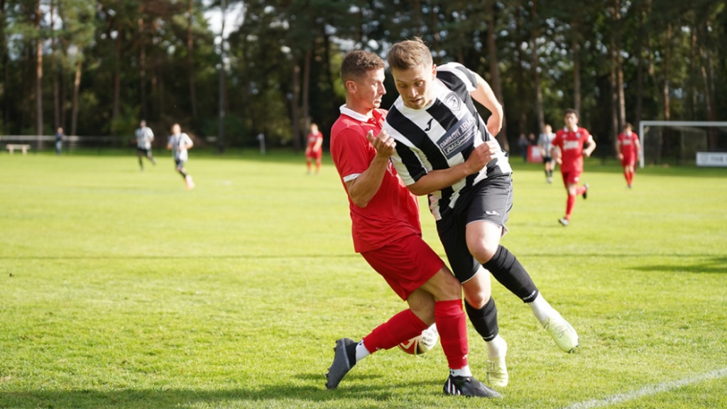 Hassocks midfielder Mike Williamson puts in a tackle against Loxwood