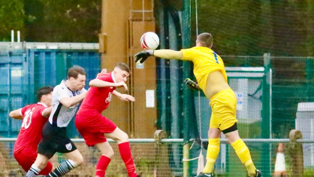 Hassocks goalkeeper Alex Harris claims a cross against Bexhill United