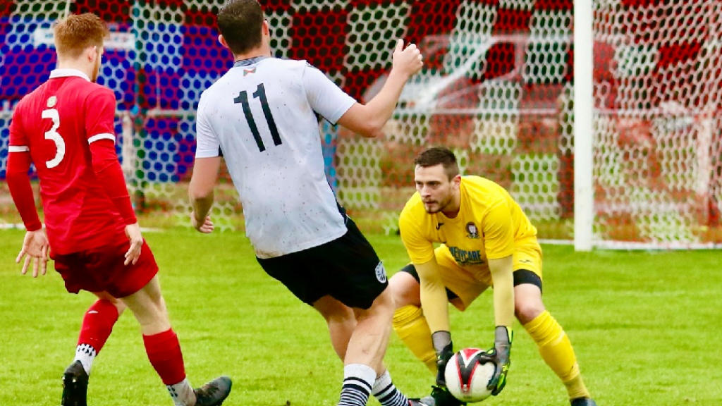 Hassocks goalkeeper Alex Harris gathers a low ball against Bexhill United