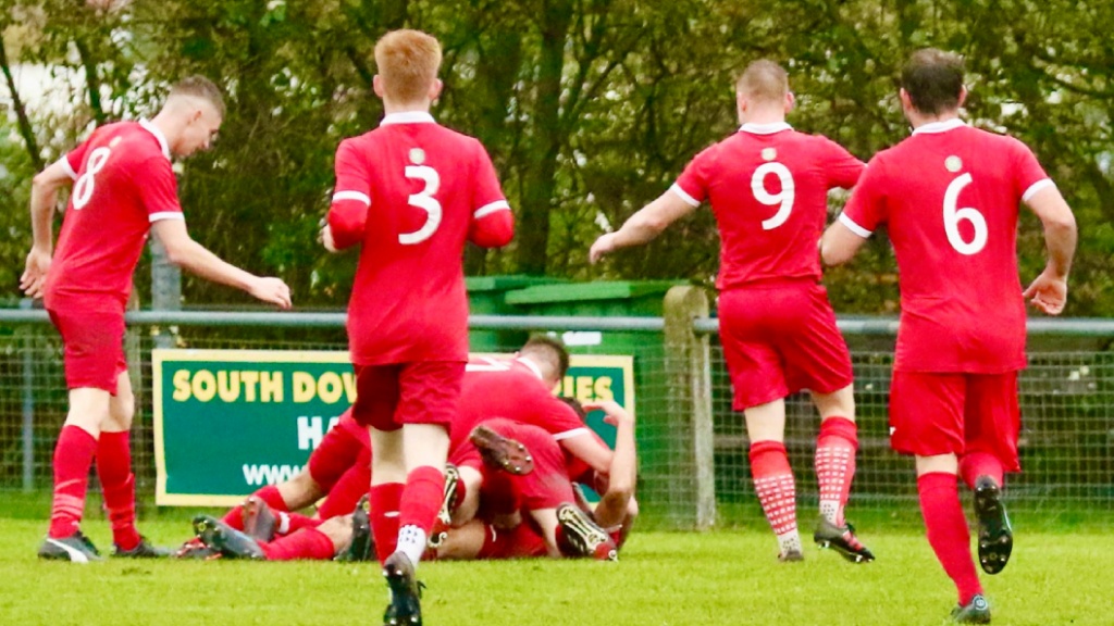 Hassocks players celebrate Liam Benson opening the scoring against Bexhill United