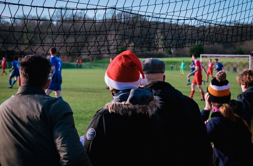 A Hassocks fan wearing a Santa hat watching football at the Beacon