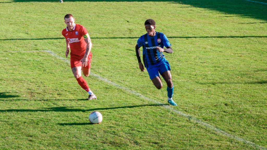Hassocks defender Alex Bygraves chases a Steyning Town opponent