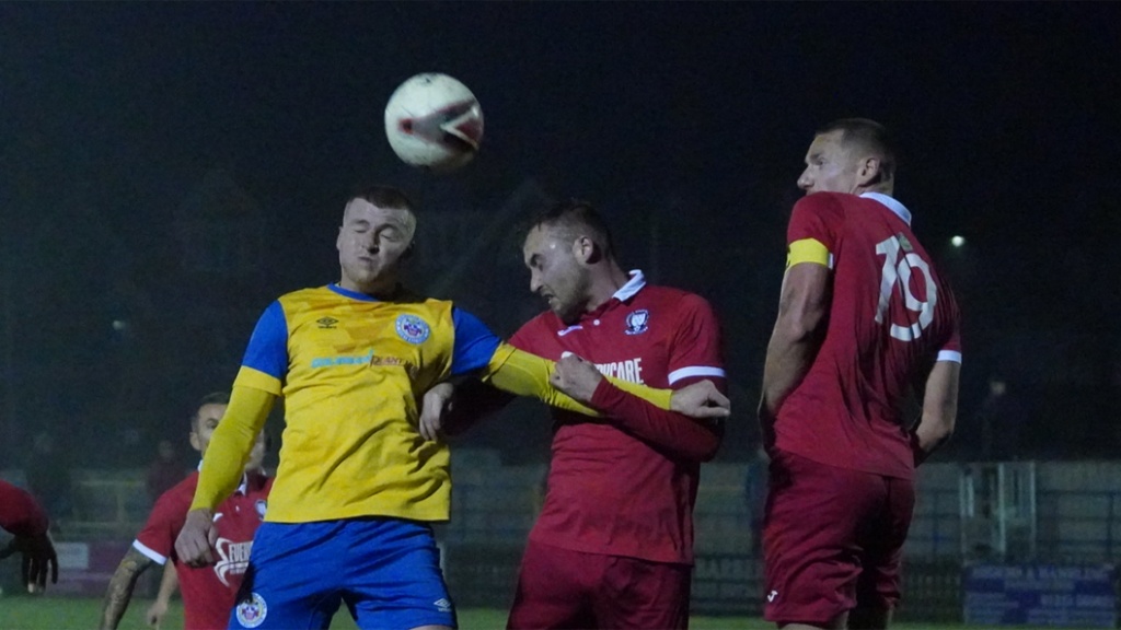 Hassocks defenders Alex Bygraves and Sam Smith challenge for a header at Eastbourne Town