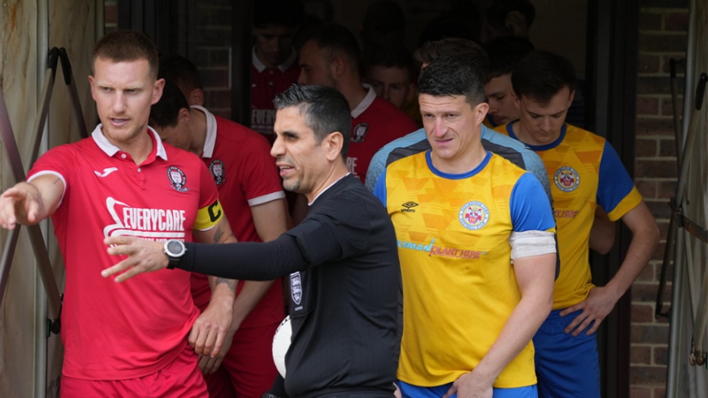 Hassocks captain Alex Bygraves talks to the referee before the game against Eastbourne Town