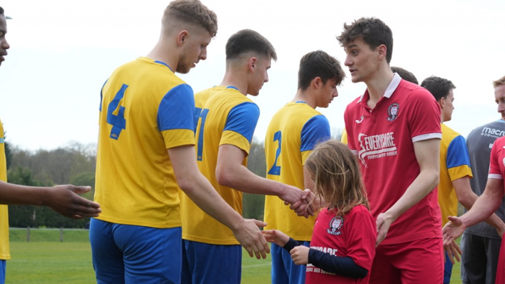 Hassocks midfielder Jack Troak shakes hands with Eastbourne Town players