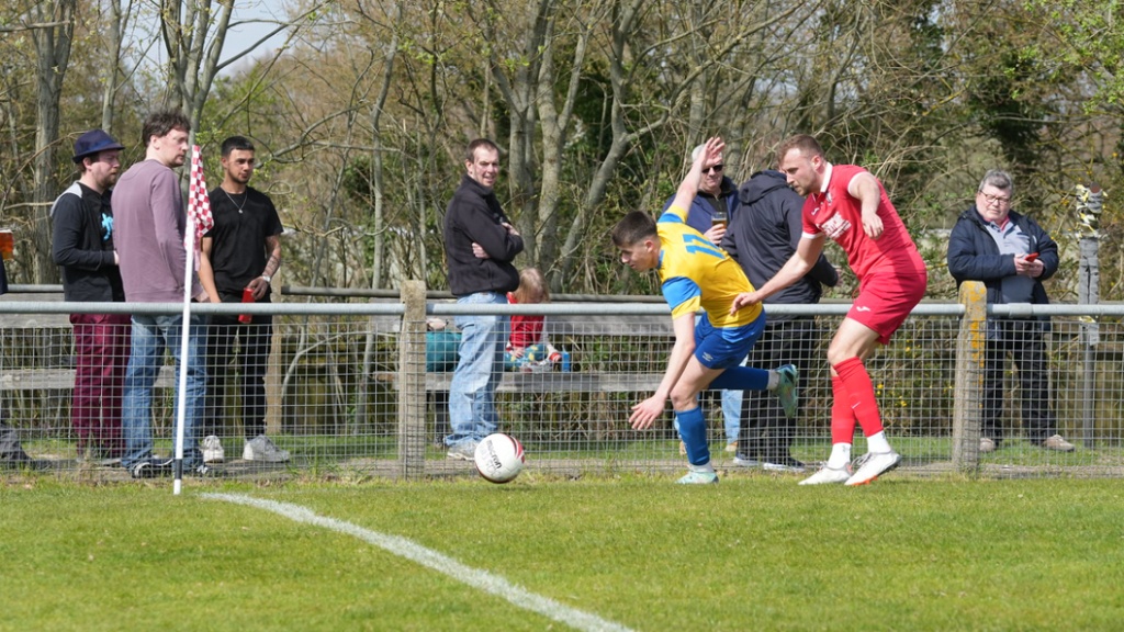 Sam Smith of Hassocks makes a tackle against Eastbourne Town