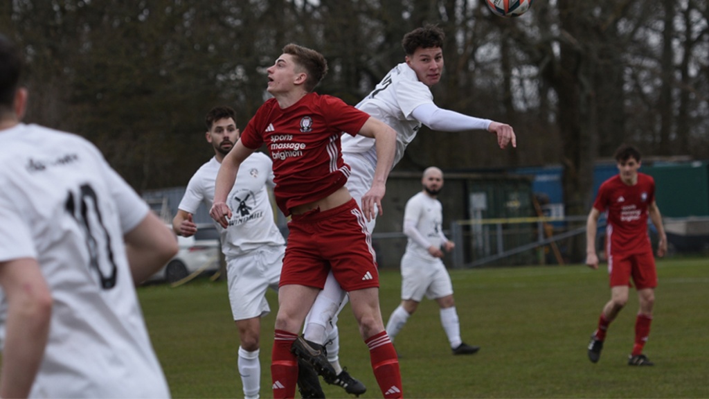 Jamie Wilkes challenges for a header for Hassocks against Eastbourne United