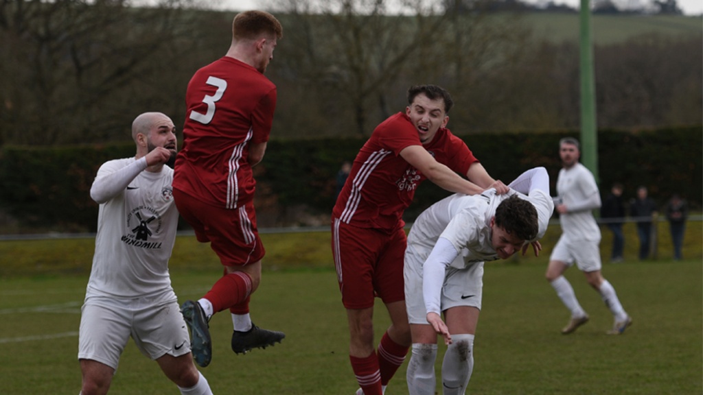 Joe Bull and Sean Stephenson challenge for the ball for Hassocks against Eastbourne United