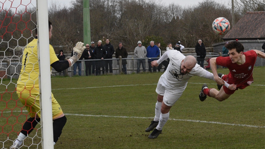 Jack Troak with a diving header for Hassocks against Eastbourne United