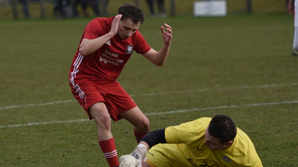 Sean Stephenson of Hassocks can't quite get to the ball ahead of Eastbourne United goalkeeper James Broadbent