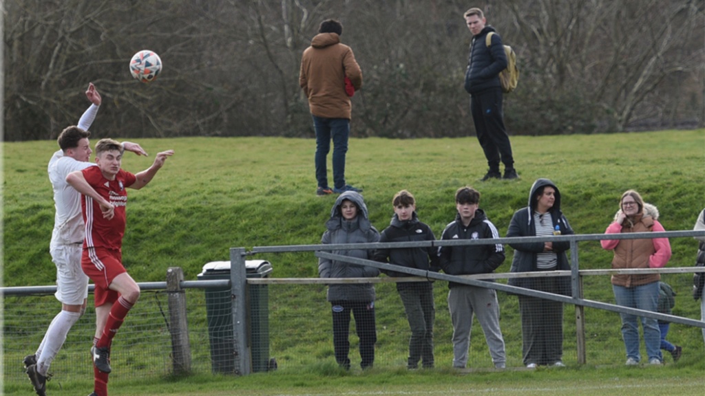 Hassocks midfielder Jamie Wilkes challenges an Eastbourne United player for a header